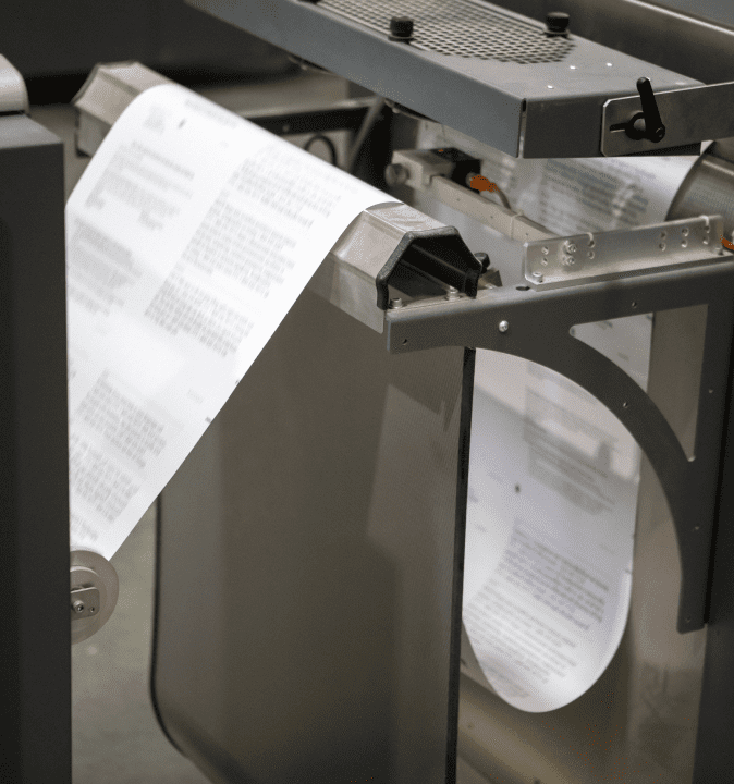Paper is run through an industrial printing machine