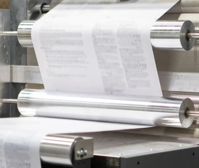 Paper rolling through an industrial printing machine