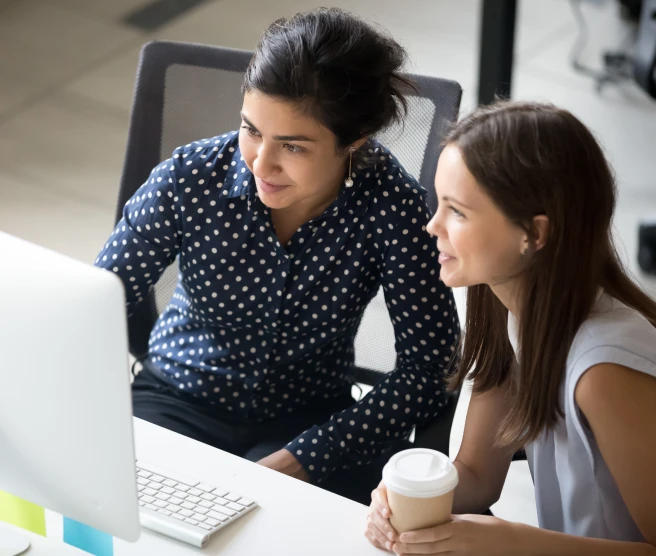 Two people working together on a desktop computer