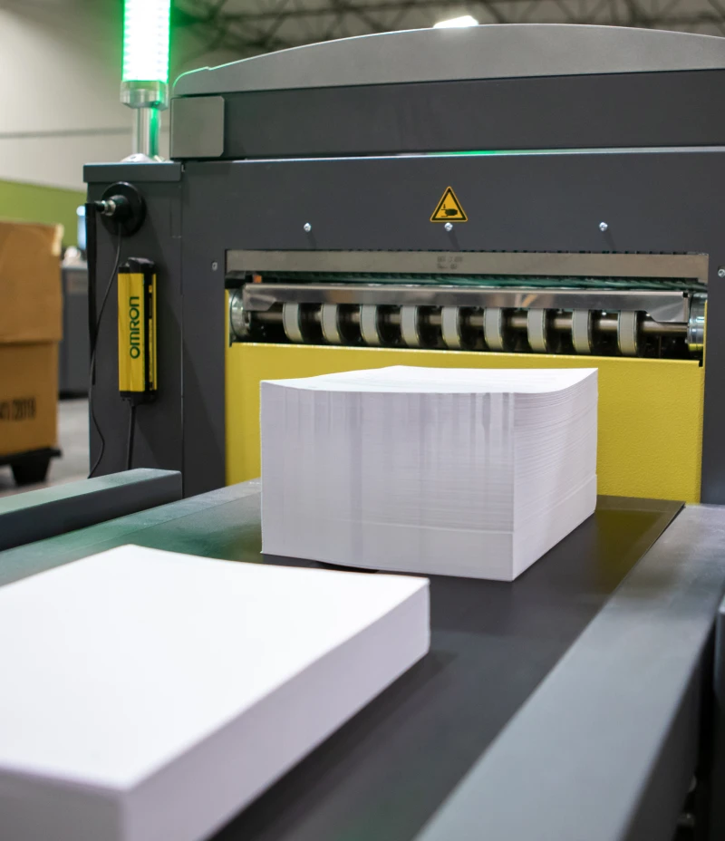 Stacks of paper on a machine's conveyer belt