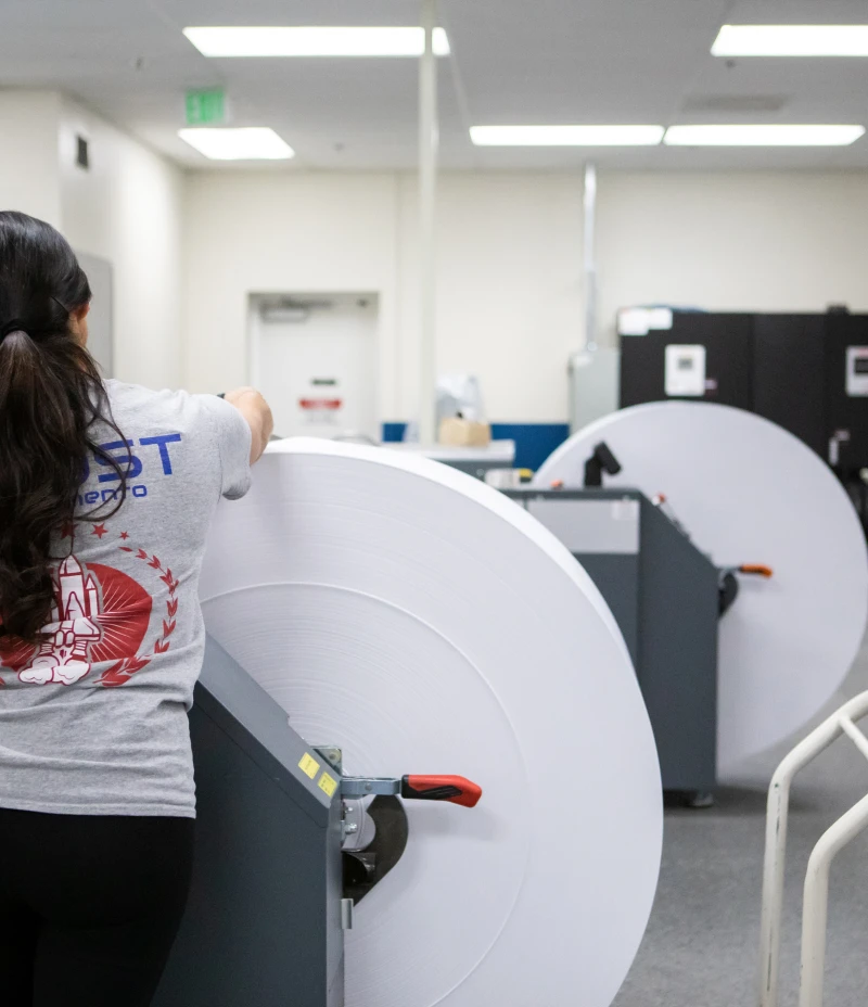 Woman working on large rolls of paper