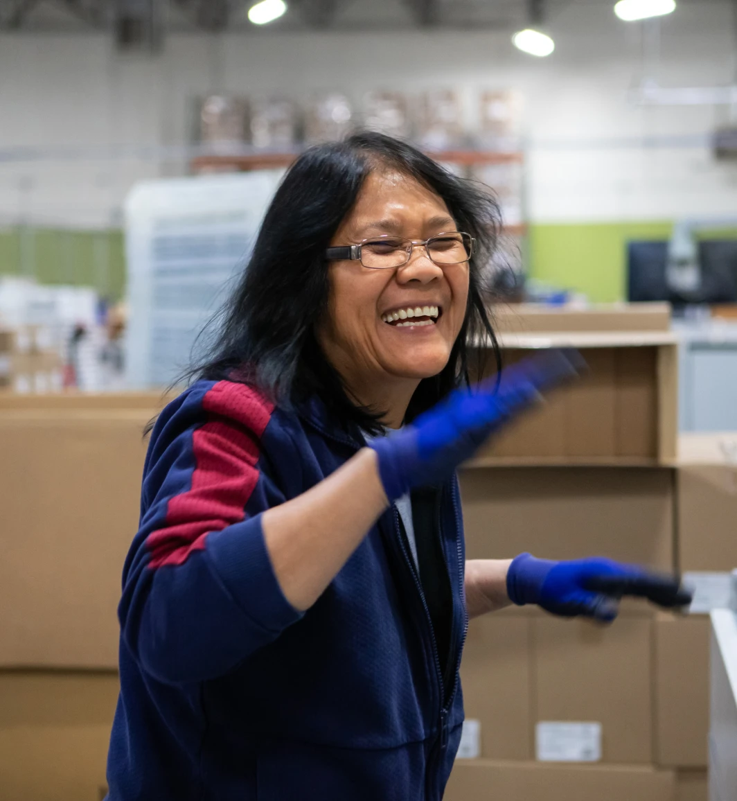 Woman laughing while working among boxes