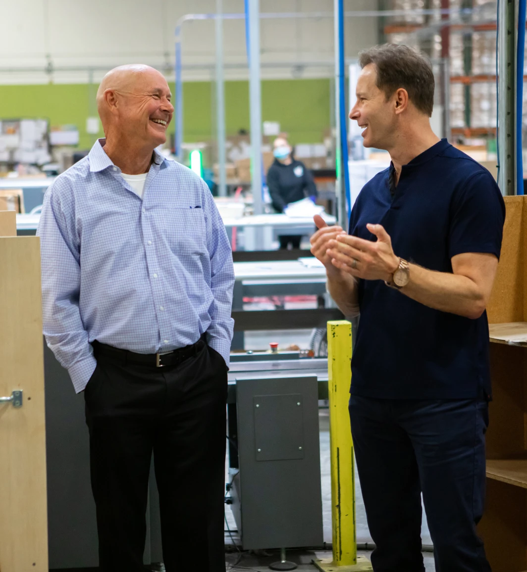 Two men talking and laughing in a production facility