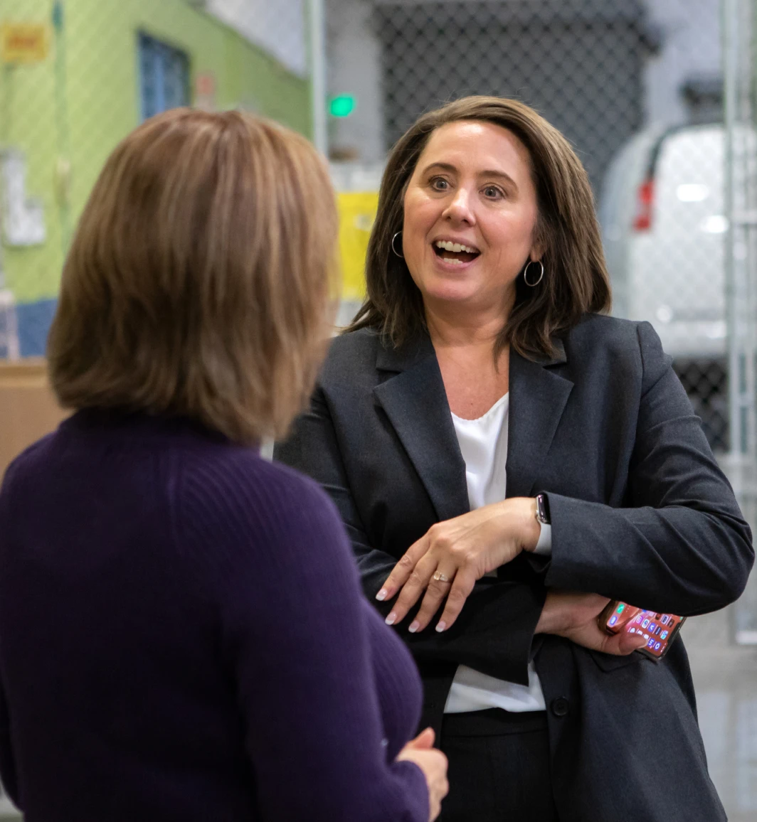 two women in blazers talking