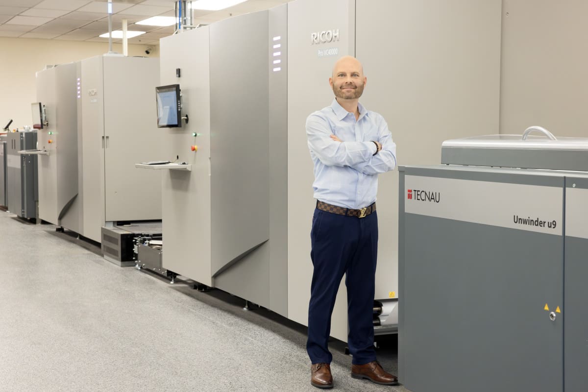 man standing in front of printing machines
